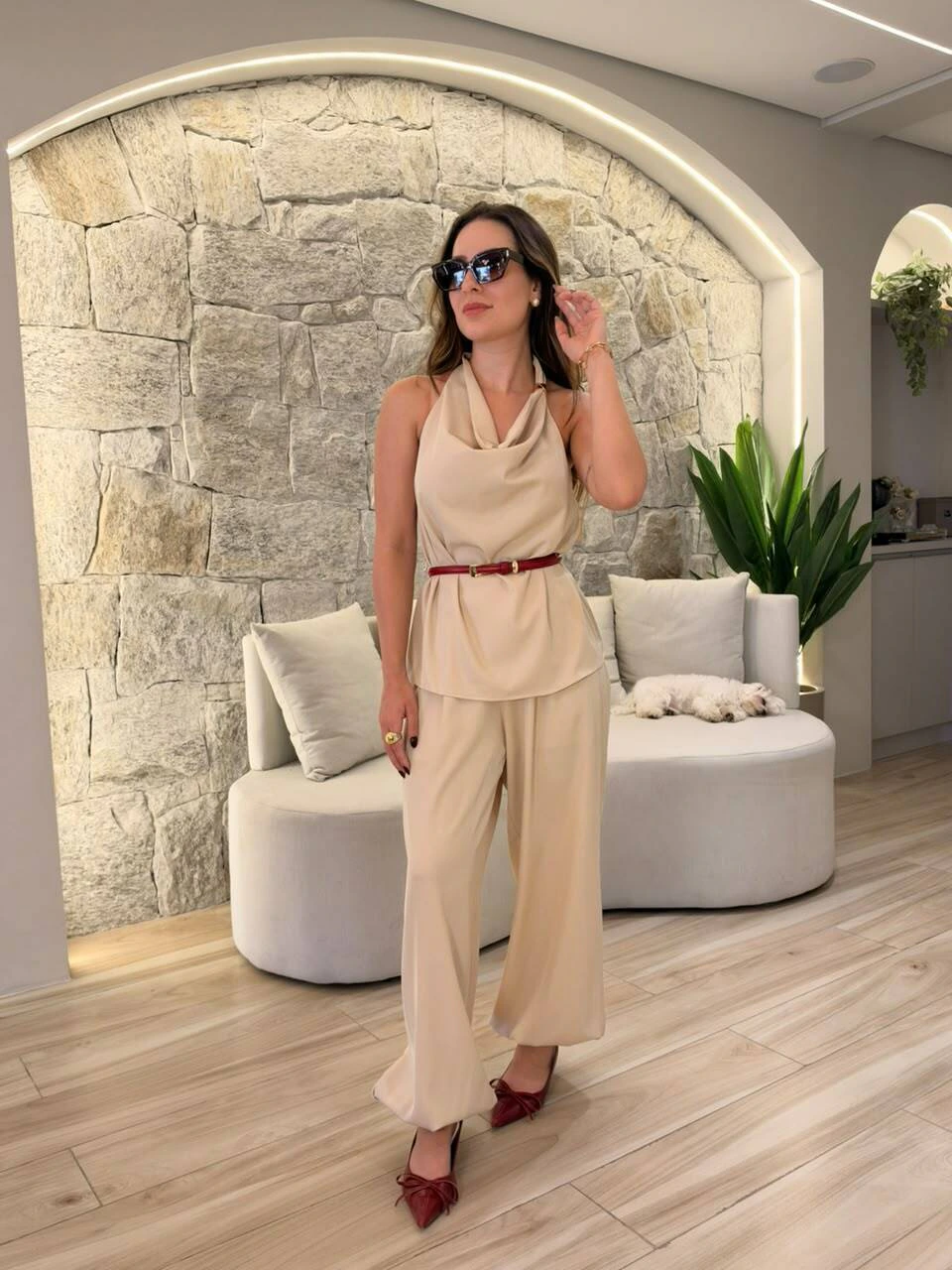 Modelo com conjunto bege de blusa frente única e calça